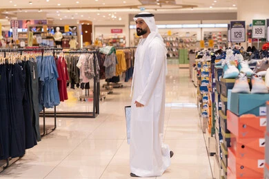 رجل إماراتي يتسوق في متجر ملابس حديث