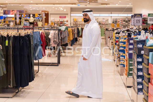 Emirati Man Shopping in Modern Retail Clothing Store