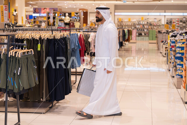 رجل إماراتي يتسوق في متجر ملابس بمركز تجاري