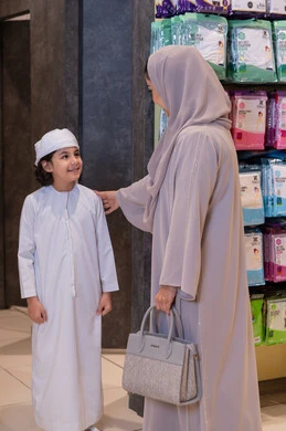 Emirati Mother and Son in Traditional Clothing Shopping