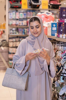 امرأة سعودية تتسوق أحذية أطفال في متجر