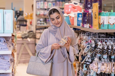 امرأة سعودية تتسوق لشراء أحذية أطفال في متجر