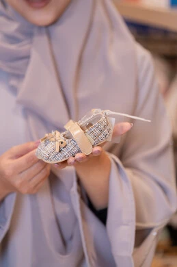 امرأة سعودية تحمل حذاء طفل في متجر ملابس