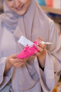 امرأة سعودية تتسوق لشراء حذاء طفل في المتجر