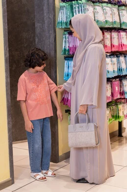 أم سعودية تتسوق مع ابنها في متجر ملابس