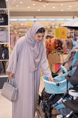 Arab Woman Shopping for Baby Stroller in Store