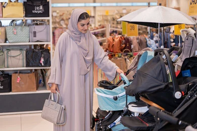 امرأة سعودية تتسوق لشراء عربة أطفال في متجر