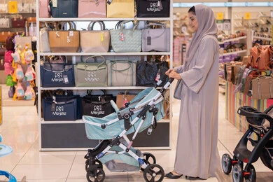 Arab Woman with Baby Stroller in Handbag Store
