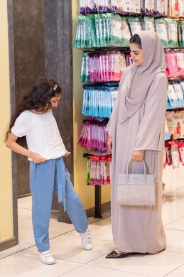أم سعودية وابنتها تتسوقان في متجر ملابس