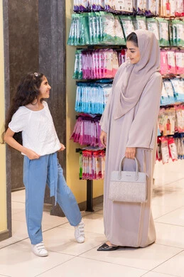 امرأة سعودية وفتاة تتسوقان في متجر لبيع الملابس