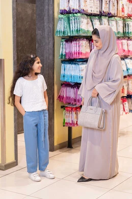 أم سعودية وابنتها تتسوقان في متجر ملابس