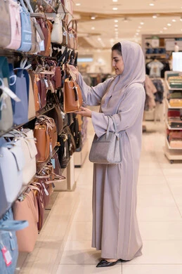 Arab Woman in Abaya Shopping for Handbags in Retail Store