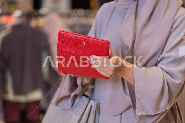 Arab Woman Holding Red Wallet in Retail Store