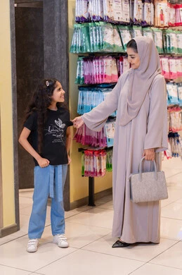 أم وابنتها سعوديات يتسوقان في متجر ملابس