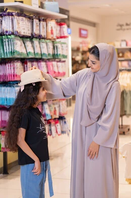 أم سعودية وابنتها تتسوقان في متجر ملابس