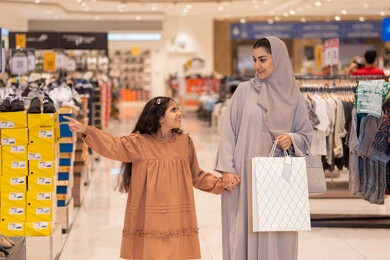 أم عربية وابنتها تتسوقان في مركز تجاري حديث