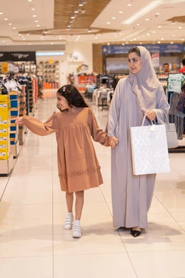 أم سعودية وابنتها تتسوقان في مركز تجاري حديث