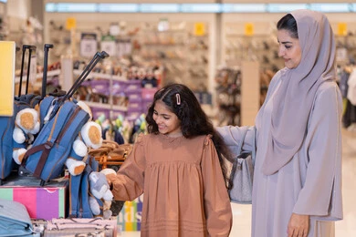 Arab Mother and Daughter Shopping for Backpacks in Mall