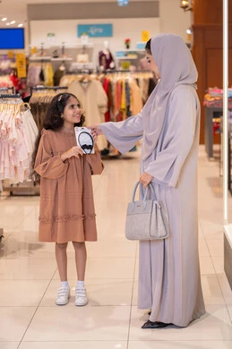 Saudi Mother and Daughter Shopping in Clothing Store