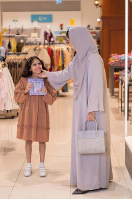 Emirati Mother and Daughter Shopping at Clothing Store