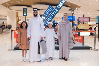 عائلة إماراتية مع حقائب تسوق في المول