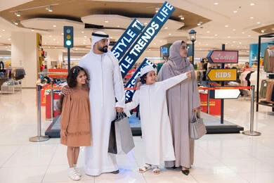 عائلة إماراتية تتسوق في مركز تجاري مع حقائب