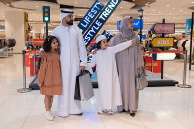 Emirati Family Shopping in Modern Mall with Bags