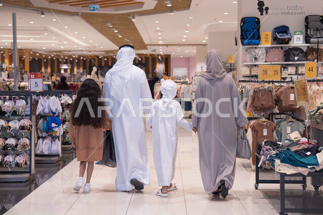 عائلة إماراتية تتسوق في مركز تجاري رؤية خلفية