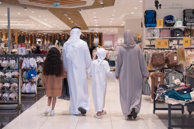 عائلة إماراتية تتسوق في مركز تجاري رؤية خلفية