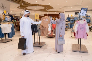زوجان إماراتيان يتسوقان لملابس الأطفال في المتجر