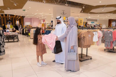 عائلة إماراتية تتسوق في متجر ملابس حديث