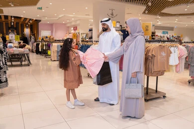 عائلة إماراتية تتسوق في متجر ملابس حديث