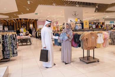 زوجان إماراتيان يتسوقان في متجر ملابس حديث