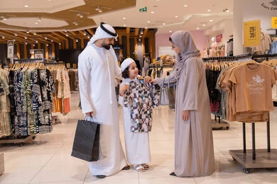 عائلة إماراتية تتسوق في متجر ملابس حديث