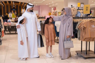 عائلة إماراتية تتسوق في متجر ملابس حديث