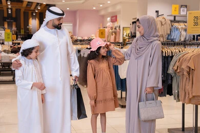 عائلة إماراتية تتسوق في متجر ملابس حديث