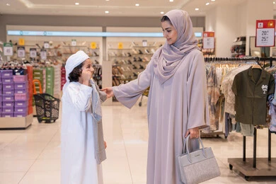 أم إماراتية وابنها يتسوقان في متجر ملابس