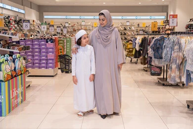 أم إماراتية وابنها يتسوقون في متجر ملابس عصري