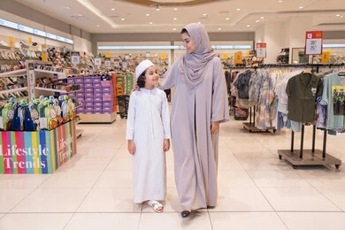 أم إماراتية وابنها يتسوقان في متجر ملابس حديث