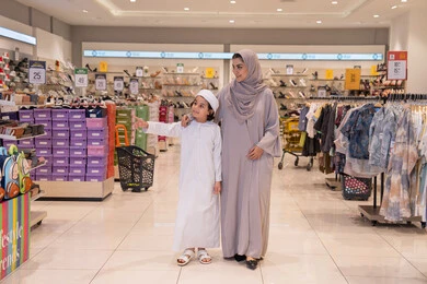 أم إماراتية وابنها يتسوقان في متجر ملابس