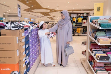 أم إماراتية وابنها يتسوقان لشراء الأحذية في المتجر