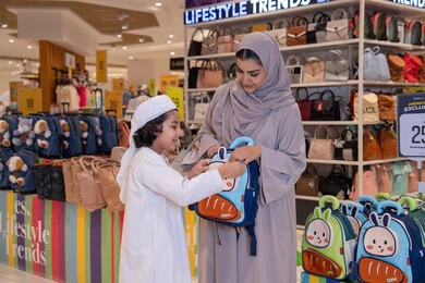 امرأة إماراتية وطفل يتسوقان لشراء حقيبة مدرسية في المول امرأة إماراتية وطفل يتسوقان لشراء حقيبة مدرسية في المول