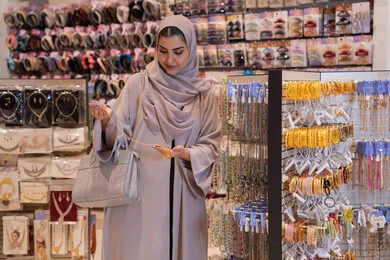 امرأة عربية تتسوق لشراء المجوهرات في متجر إكسسوارات