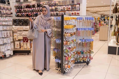 امرأة سعودية تتسوق الإكسسوارات في متجر تجزئة