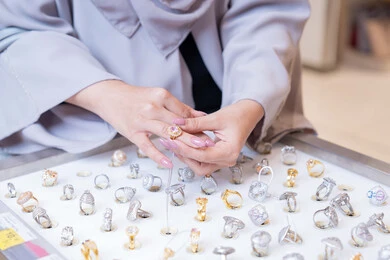 امرأة سعودية تجرب خواتم فاخرة في متجر مجوهرات