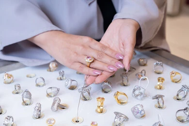 امرأة سعودية تتسوق خواتم فاخرة في متجر مجوهرات