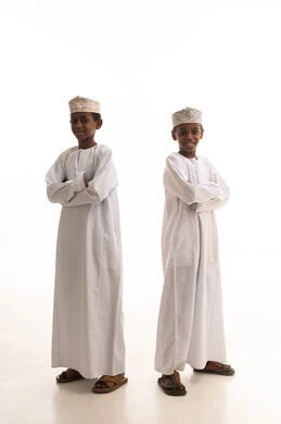 أطفال عمانيون بالزي التقليدي العماني بخلفية بيضاء