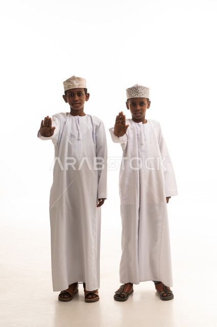 Omani Boys in Traditional Dress Making Stop Gesture