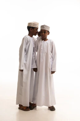 أطفال عمانيون بالزي التقليدي يتهامسون في الاستوديو