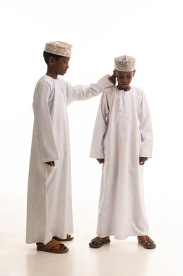 Two Omani Boys in Traditional Dishdasha and Kumma